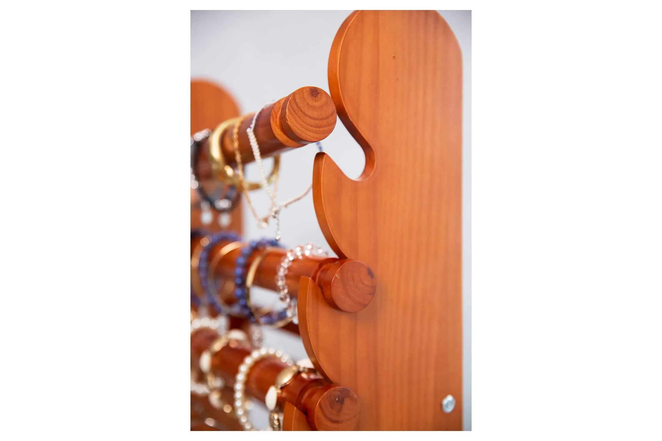 Close-up of an 18-inch removable wooden bar loaded with beaded bracelets